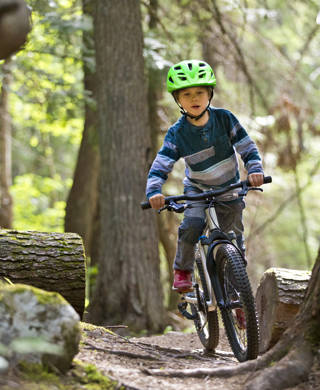 Jongen rijdt met mountainbikefiets door het bos