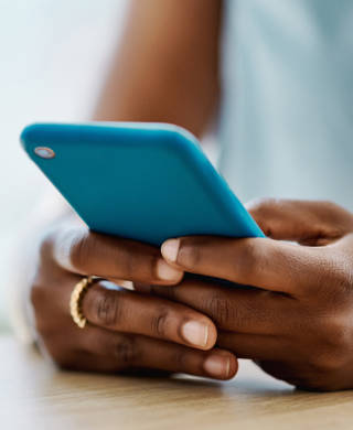 Afrikaanse vrouw met gsm, enkel handen zichtbaar