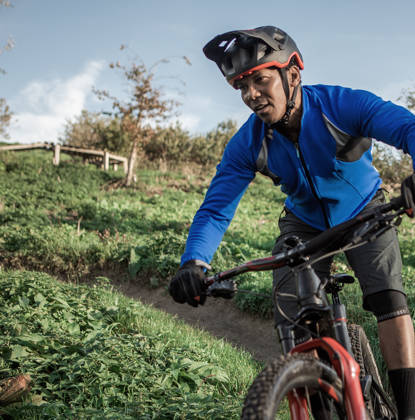 Man rijdt met mountainbikefiets door de weilanden