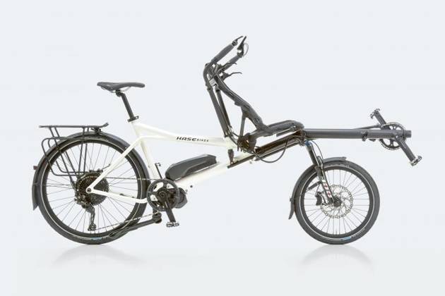 G-fiets waarbij de bestuurder achteraan zit en de G-sporter vooraan in de ligfiets kan meetrappen met de armen.