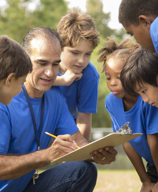 Multi culturele groep schoolkinderen luisteren naar hun coach