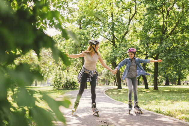 Moeder en dochter rolschaatsen in park