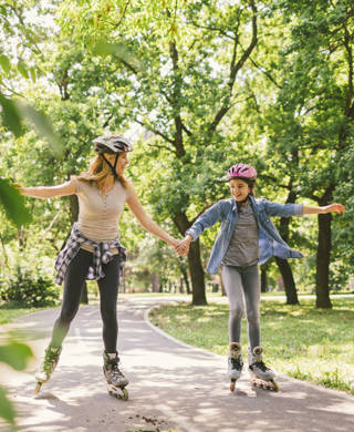 Moeder en dochter rolschaatsen in park