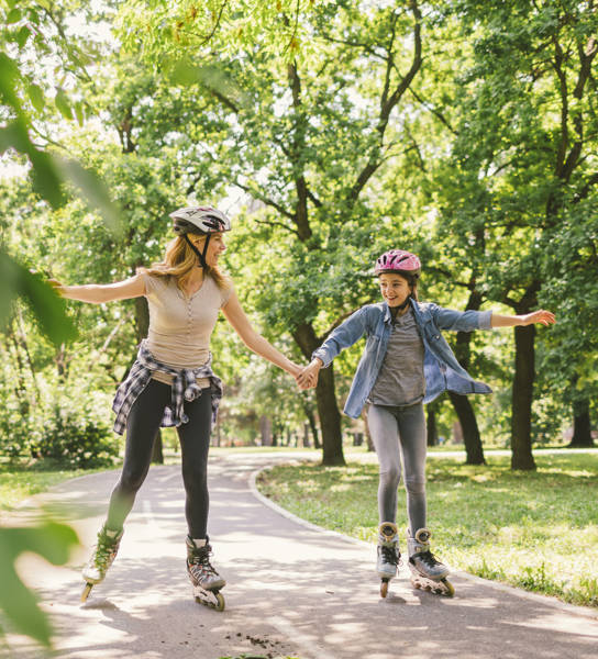 Moeder en dochter rolschaatsen in park