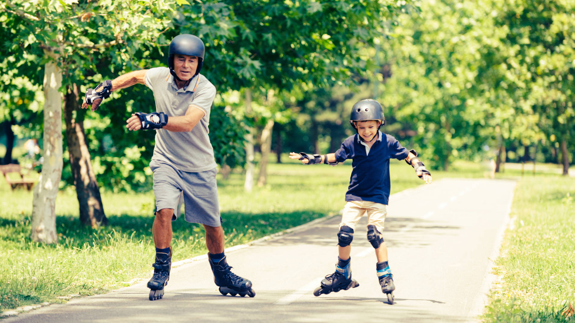 Vader en zoon rolschaatsen in park