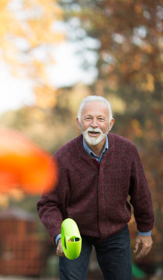 Photo of a grandfather playing with grandson outdoors