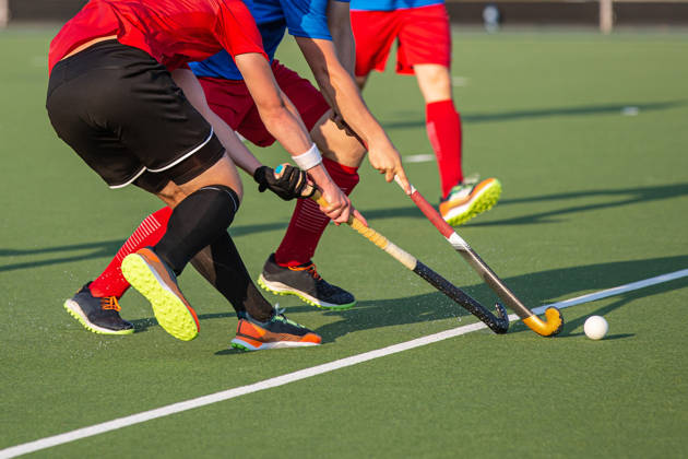 Twee hockeyspelers vechten om bal met stick
