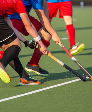 Twee hockeyspelers vechten om bal met stick