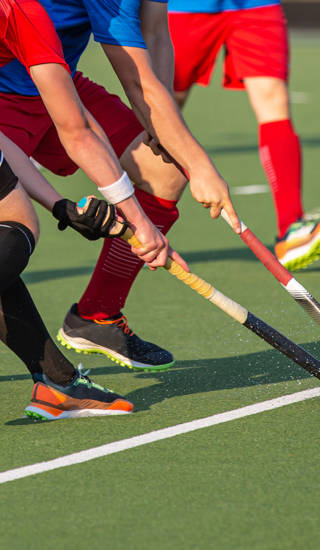 Twee hockeyspelers vechten om bal met stick