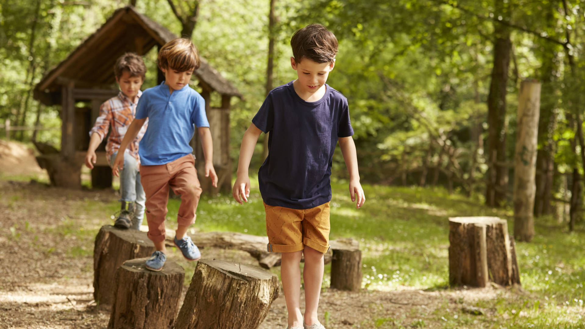 Multimove beeld van kleuters die wandelen op boomstammen