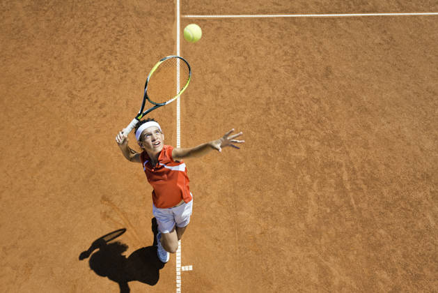 Jongen slaat op met tennisracket