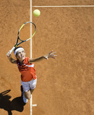 Jongen slaat op met tennisracket