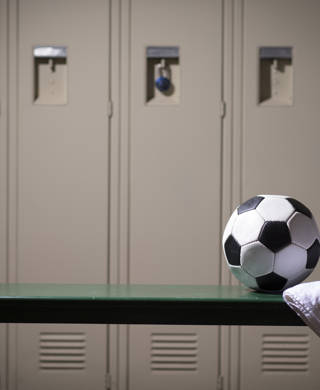 Lockers in kleedkamer en voetbal op bank