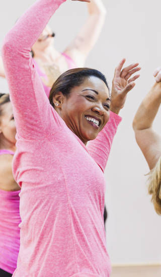 Multi-culturele groep dames dansen met handen in de lucht