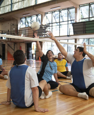 Several disabled athletes are training volley at an indoor court