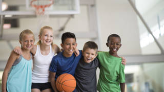 Multi culturele groep jonge kinderen met basketbal