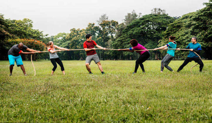 Teambuilding en highlandgames buiten met touwtrekken en paalwerpen