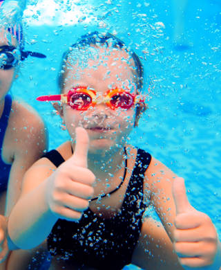 Underwater photo of young friends in swimming pool