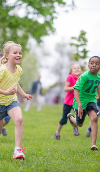 Groepje kinderen loopt op grasveld