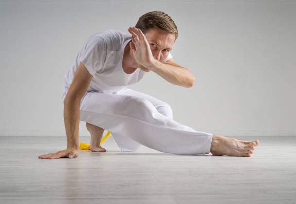 Young Man practicing capoeira (brazilian martial art with elements of dance, acrobatics and music).