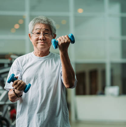 Grijze oude dame met gewichtjes in handen