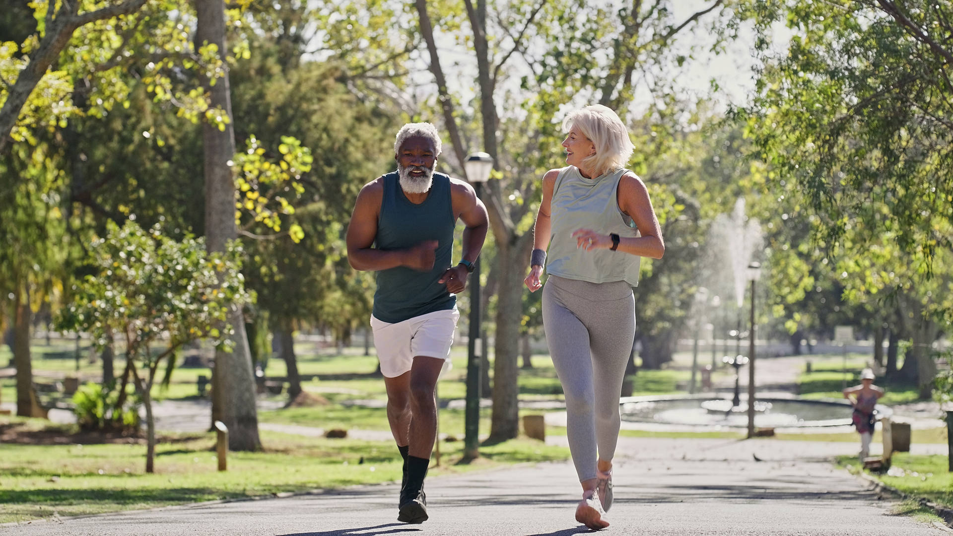 Fitness, senior people or running in park for wellness, cardio exercise or training in retirement. Elderly couple, smile or outdoor for workout with support, motivation or friends on path with energy