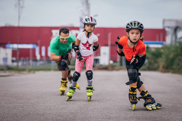 Twee meisjes en een man aan het skeeleren