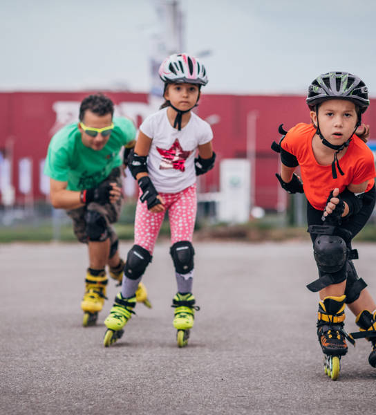Twee meisjes en een man aan het skeeleren