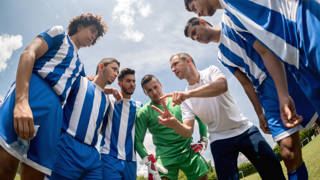 Coach legt tactiek uit voor de wedstrijd