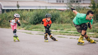Man aan het skeeleren met twee kindjes