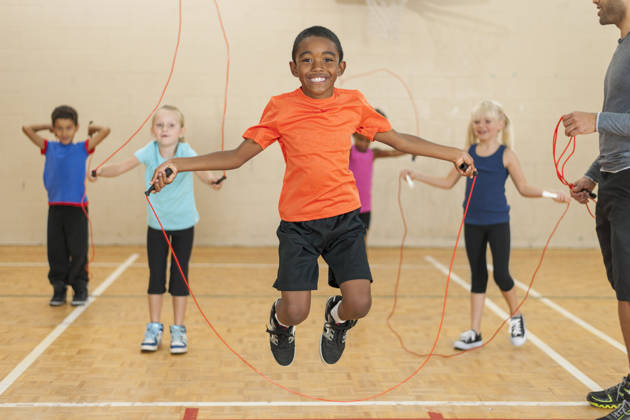 Verschillende kindjes met springtouw samen met coach