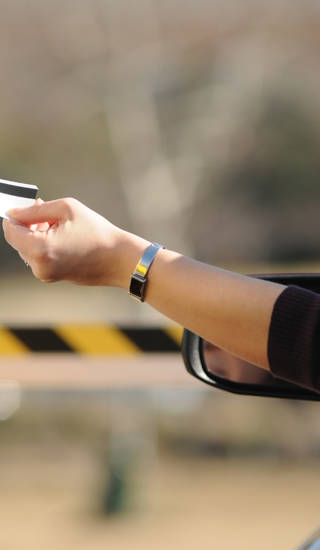 a hand reaching out to insert parking voucher for parking payment