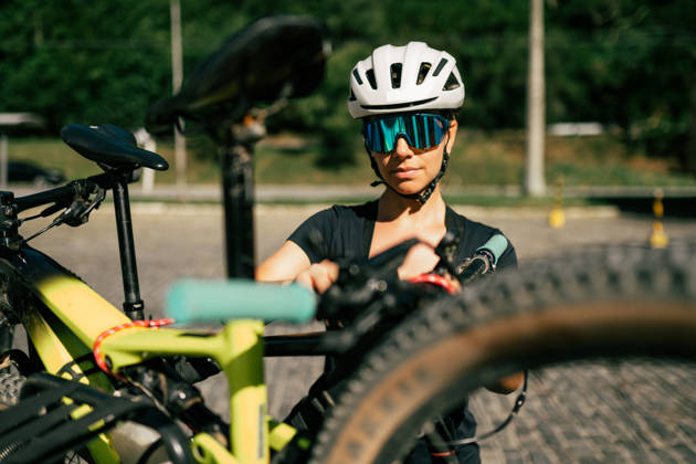 Young woman, putting a bike in the car for a trip