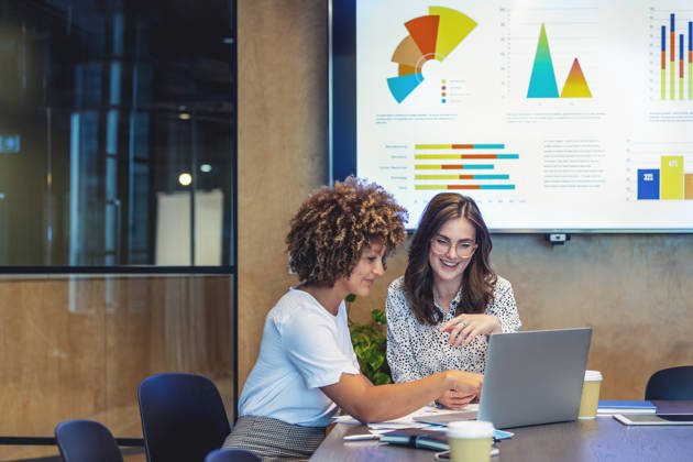 collega's aan bureau met grafieken op scherm