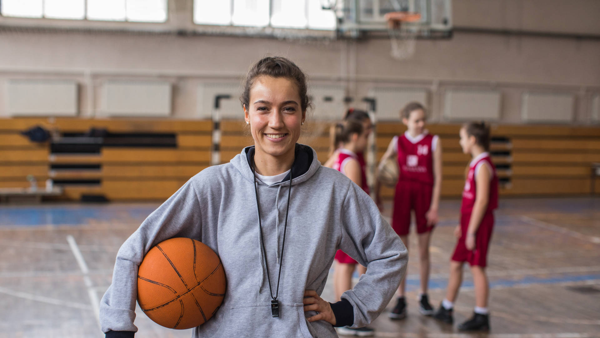 Vrouwelijke basketbalcoach met een jong team in sporthal