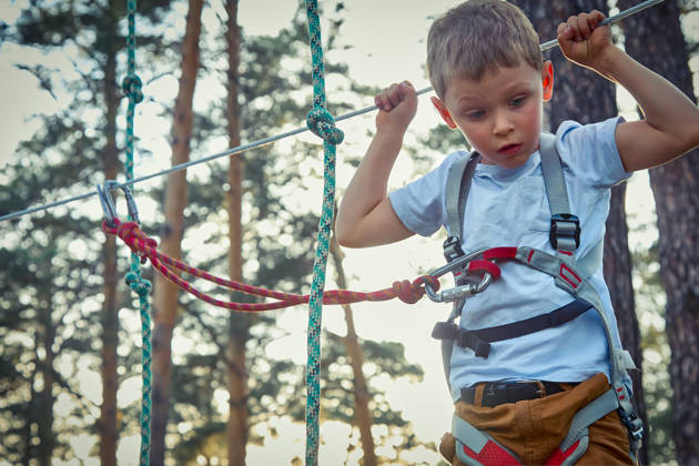 Jongen op hoogtouwenparcours