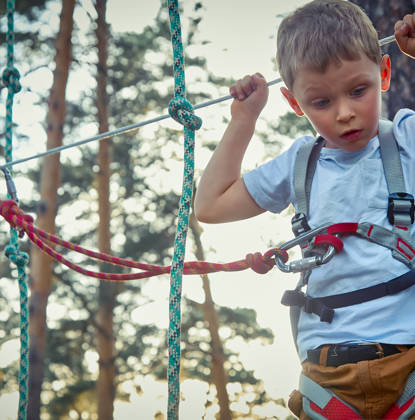 Jongen op hoogtouwenparcours