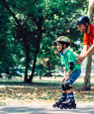 Little boy learning roller skating in the park