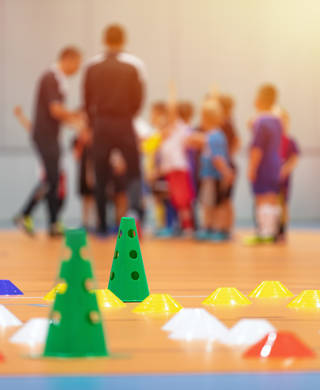 sportterrein met divers materiaal en sporters op de achtergrond