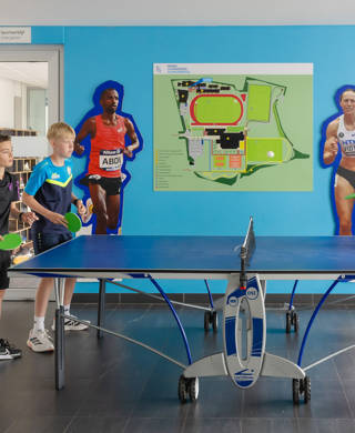 4 kinderen spelen tafeltennis in inkom sportverblijf