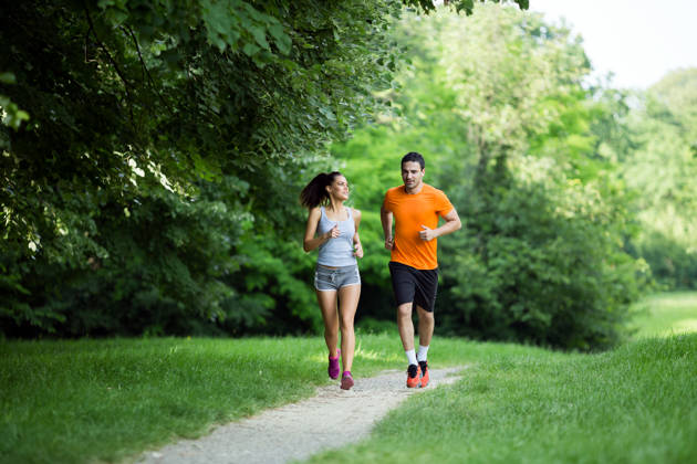 Athletic couple jogging in nature in good spirit