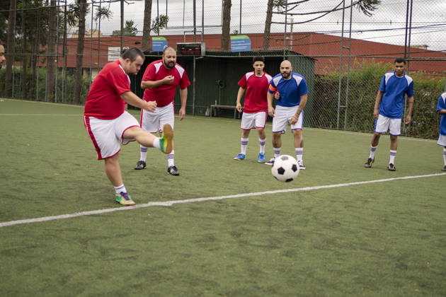 Soccer player with Down Syndrome kicking the ball during friendly game