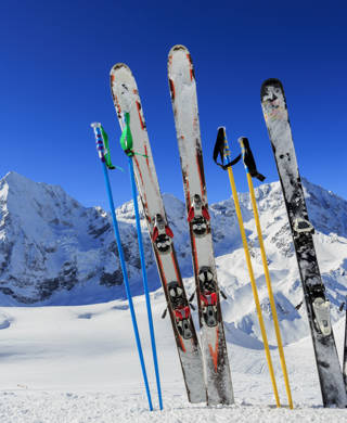 Twee paar skilatten met skistokken in de sneeuw