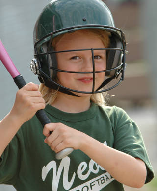 Jonge baseballspeelster wacht om op baseballbal te slaan