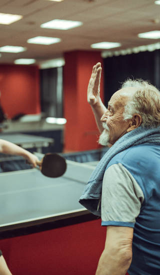 Opa en kleinzoon spelen tafeltennis en doen high five
