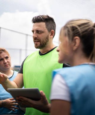 Coach and female soccer players planning a game