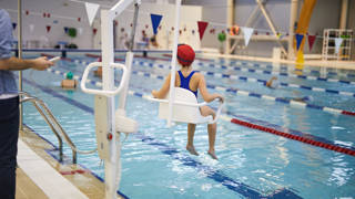 Meisje wordt met lift in zwembad gebracht