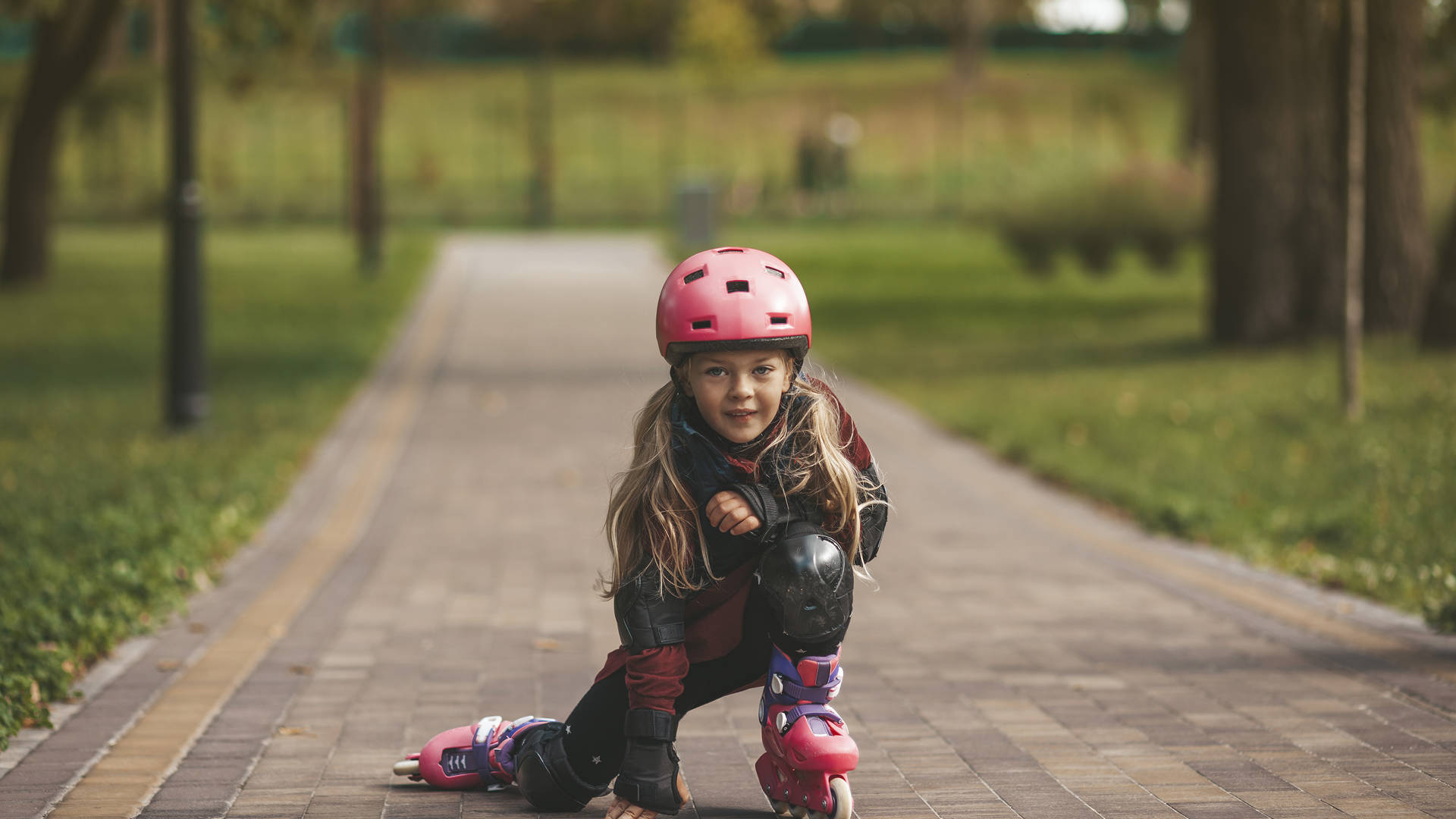 Meisje met helm op rolschaatst op de weg