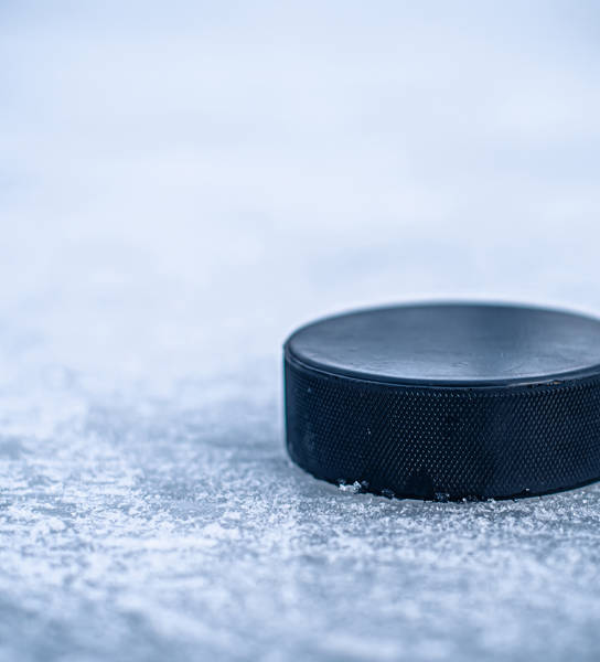 hockey puck lies on the snow macro