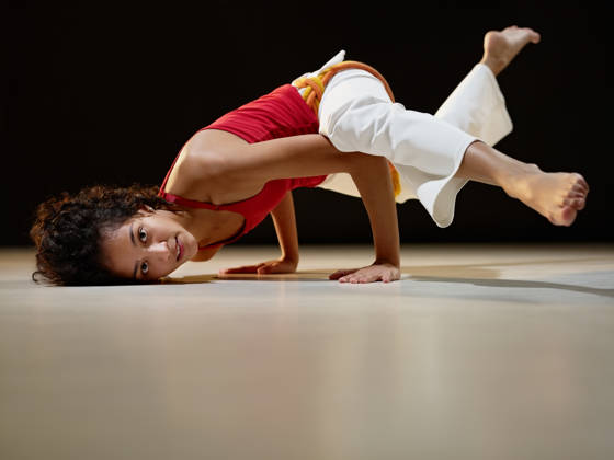 portrait of young adult latin american female doing yoga and capoeira in gym. Horizontal shape, full length, side view, copy space